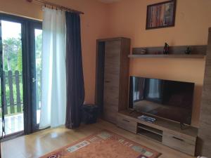 a living room with a flat screen tv next to a window at Kiss Apartman in Balatonberény