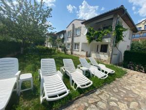 a group of lawn chairs sitting in the grass at Complex Sea & Sky next to the Beach ! in Kranevo