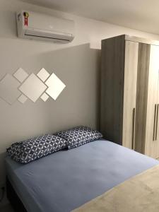 Un dormitorio con una cama y una luz en la pared. en Apartamento, Apart Hotel, 02 Quartos - Arraial do Cabo, en Arraial do Cabo 15 fotos más