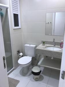 Un baño blanco con inodoro y lavabo. en Apartamento, Apart Hotel, 02 Quartos - Arraial do Cabo, en Arraial do Cabo