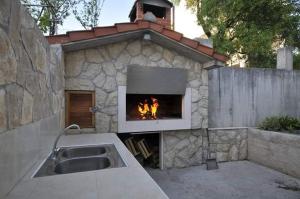 uma lareira num edifício de pedra com uma fogueira em Antonio em Kaštela