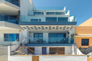 メレナラにあるTop Views Melenara Beach Avenue Apartmentsの階段とバルコニー付きの広い白い家