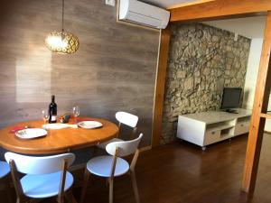 a dining room with a table and chairs and a television at Apartment Vladka PARK in Izola