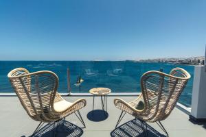 メレナラにあるTop Views Melenara Beach Avenue Apartmentsの海を望むバルコニー(椅子2脚、テーブル1台付)