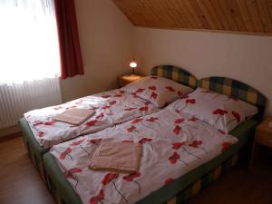 Un dormitorio con una cama con flores rojas. en Apartment in Siofok - Balaton 35634, en Siófok