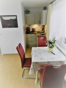 een keuken met een tafel en rode stoelen en een tafel en een tafel bij Holiday home in Bergen auf Rügen 2852 in Bergen auf Rügen
