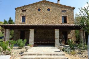 an old stone house with a large brick building at Ca La Piera, Le Marche, Italy in Piandimeleto