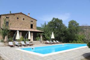 a swimming pool in front of a building with a house at Ca La Piera, Le Marche, Italy in Piandimeleto