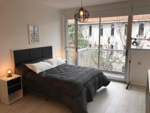 a bedroom with a large bed and a large window at Studio en Palermo Hollywood in Buenos Aires