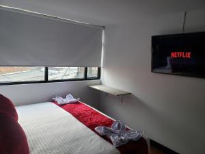 1 dormitorio con 1 cama con TV y arcos en AW Hotel American Travel, en Bogotá