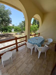 a room with a table and chairs on a balcony at Lemon Garden in Agios Georgios
