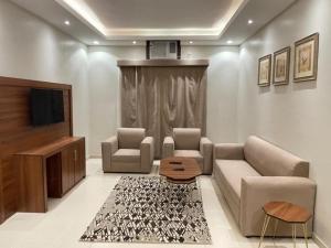 a living room with a couch and two chairs and a tv at Rest inn in Medina