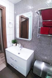 y baño con lavabo blanco y espejo. en Yes O'K96577триста два пять пять, en San Petersburgo