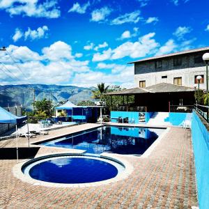 - une piscine avec une passerelle en briques à côté d'un bâtiment dans l'établissement Hostería Vista Del Valle, à Hacienda Santa Isabel