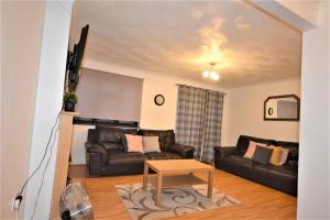 a living room with a couch and a table at Spacious 3 bedroom House in Tilbury by London in Low Street