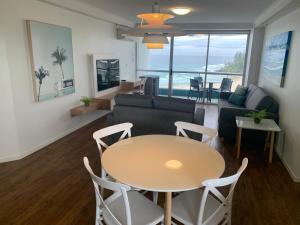 un salon avec une table, des chaises et un canapé dans l'établissement Ocean Plaza Resort, à Gold Coast
