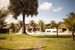 a palm tree and a stone path in front of a house at Geribá Beach Apart Hotel apt504 in Búzios