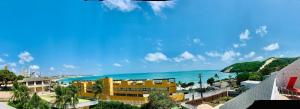 een uitzicht op een geel gebouw en de oceaan bij Maravilhoso flat com vista para o Mar de Ponta Negra in Natal