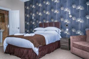 una camera da letto con un letto grande con una parete blu di Sutherland House a Oban