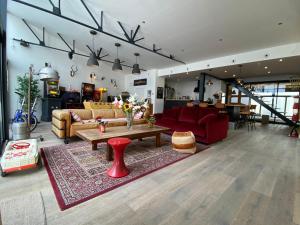uma sala de estar com um sofá vermelho e uma mesa em Loft Spa Reims-fr 250m2 privatifs, piscine intérieure chauffée, spa et parking em Reims