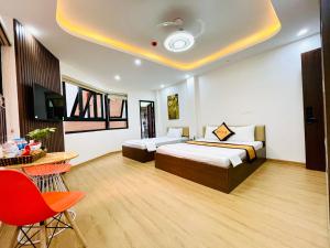 um quarto de hotel com duas camas e uma mesa e cadeiras em A&EM VILLA em Hanói