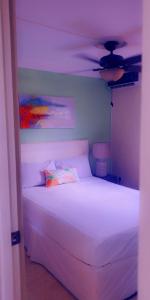 a bedroom with a white bed with a ceiling at Apartment Soleil- Because Location really is everything! in Soufrière