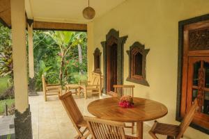 comedor con mesa de madera y sillas en Lendang Eco Lodge en Senggigi 