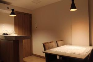 a kitchen with a table and two chairs and a counter at Flat em Vista Azul Hotel in Pedra Azul
