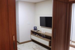 a room with a flat screen tv on a wall at Flat em Vista Azul Hotel in Pedra Azul +2 photos