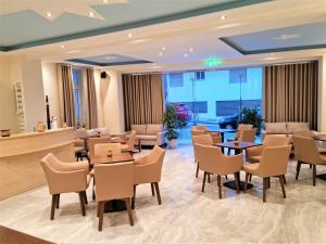 un vestíbulo de un hotel con mesas y sillas en Star Bay Luxury en Limenaria