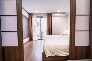 um quarto com uma cama branca e uma janela em T&B HOUSING em Hanói