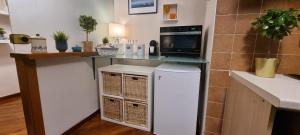 eine Küche mit einer Theke, einer Mikrowelle und einem Kühlschrank in der Unterkunft Via Battisti 109 in Caserta