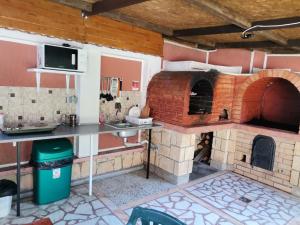 uma cozinha com um grande forno de tijolos num quarto em Vila Cristal Costinesti em Costinesti