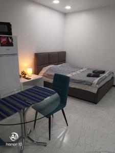 a bedroom with a bed and a chair and a desk at Lovely Apartment in City Center in Batumi