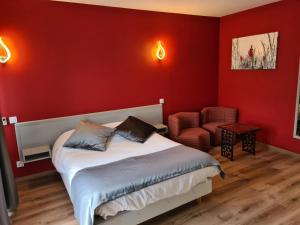 a bedroom with red walls and a bed and a chair at Bastide du Cantal in Salers