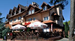 a hotel with umbrellas in front of a building at Pensjonat Resident in Krynica Morska