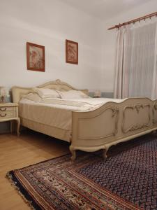 a large bed in a bedroom with a rug at Rokoko Apartman in Abádszalók