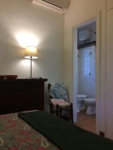 a bedroom with a bed and a lamp and a bathroom at A casa di Maurizio in Rosa Marina