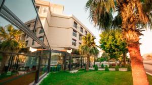 a building with a palm tree in front of it at Leaf Port Hotel in Antalya