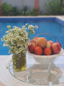 a bowl of fruit and a vase of flowers on a table at Villa "Rezi-dencia" in Batumi