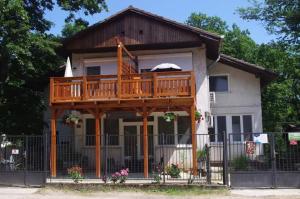 a house with a large deck on top of it at Tölgyfa Vendégház in Balatonszepezd