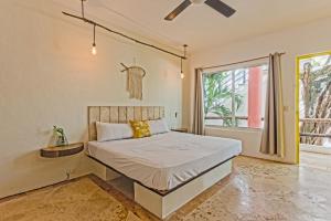 1 dormitorio con cama y ventana en Rustik-inn Rooms en Playa del Carmen