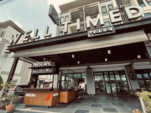 a woman sitting in a chair outside of a building at Well Timed Hotel in Krabi town