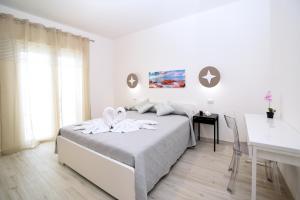 een witte slaapkamer met een bed en een bureau bij Residenza Oltremare in Peschici