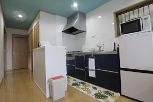 La cuisine est équipée d'un réfrigérateur et d'un four micro-ondes. dans l'établissement Yadokari Shima, à Shima