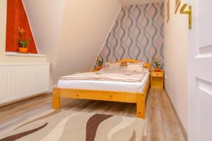 Un pat sau paturi într-o cameră la ILLÉS Apartmanok II.