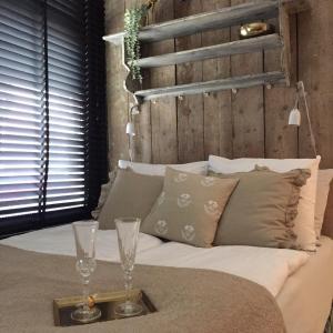 a bed with two wine glasses on a tray at Guesthouseamsterdam in Amsterdam