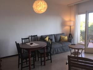 een woonkamer met een bank en een tafel en stoelen bij Apartamento con vista al mar in Llança