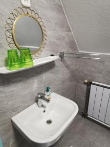y baño con lavabo blanco y espejo. en Gabi Magánszálláshely, en Zalasárszeg