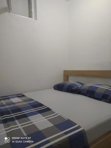 a bedroom with a bed with blue and white sheets at Apartment Maska in Budva